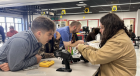 Lead instructors Cevahir Koprulu and Adam Thorpe work with interns to troubleshoot a motor control circuit. 